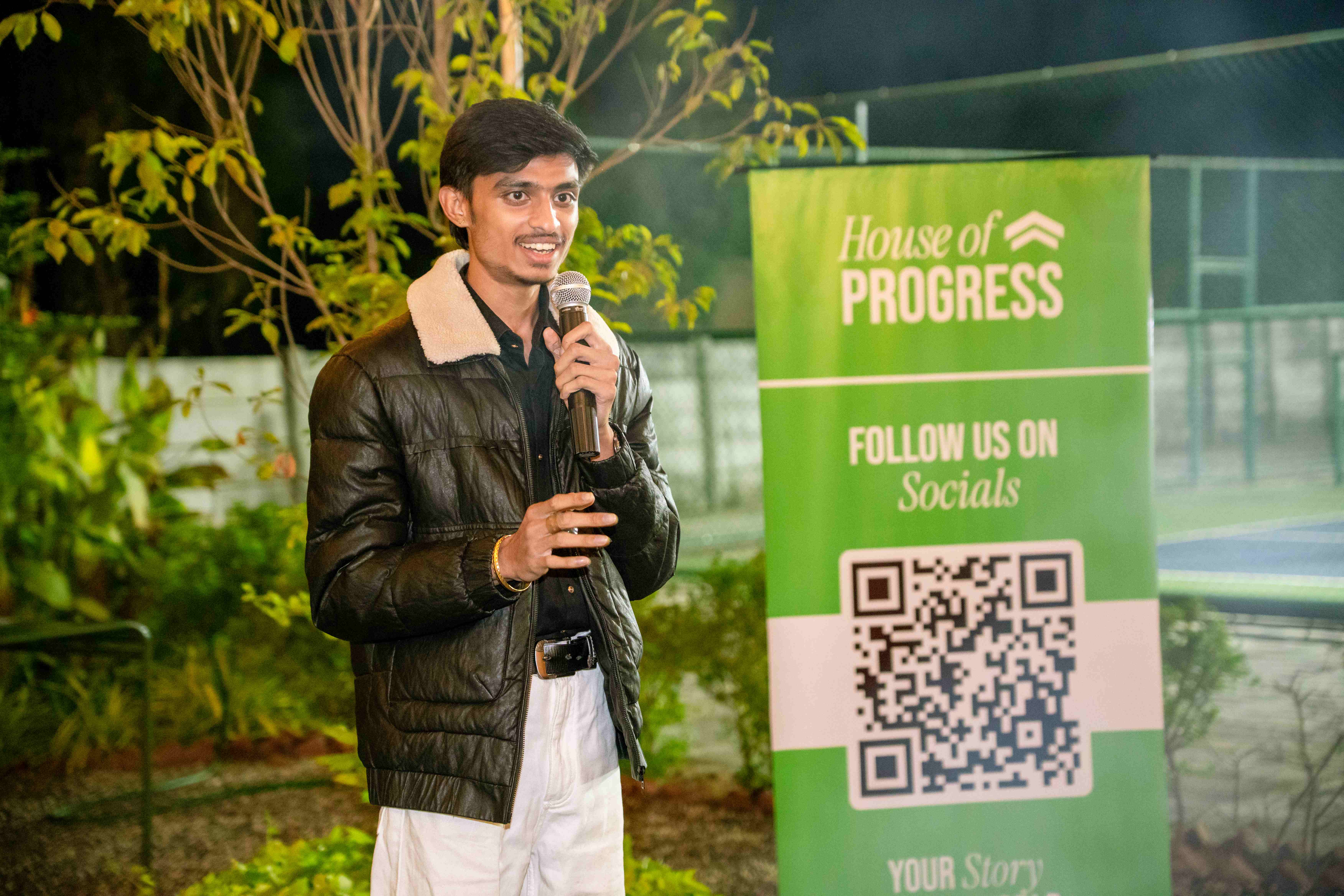 Speaker with House of Progress banner